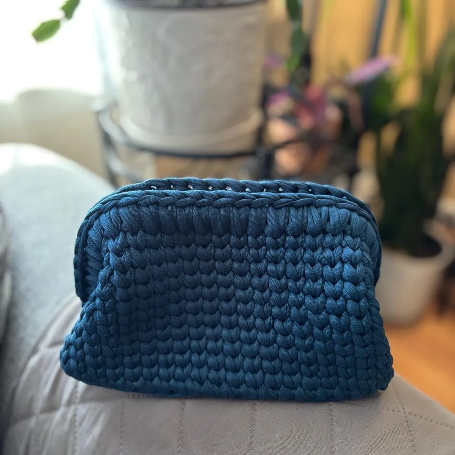 A navy T-shirt yarn clutch in waistcoat stitch.